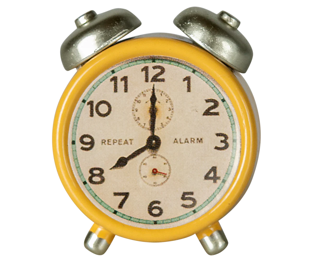 Vintage-style alarm clock with yellow casing and silver knobs on a white background