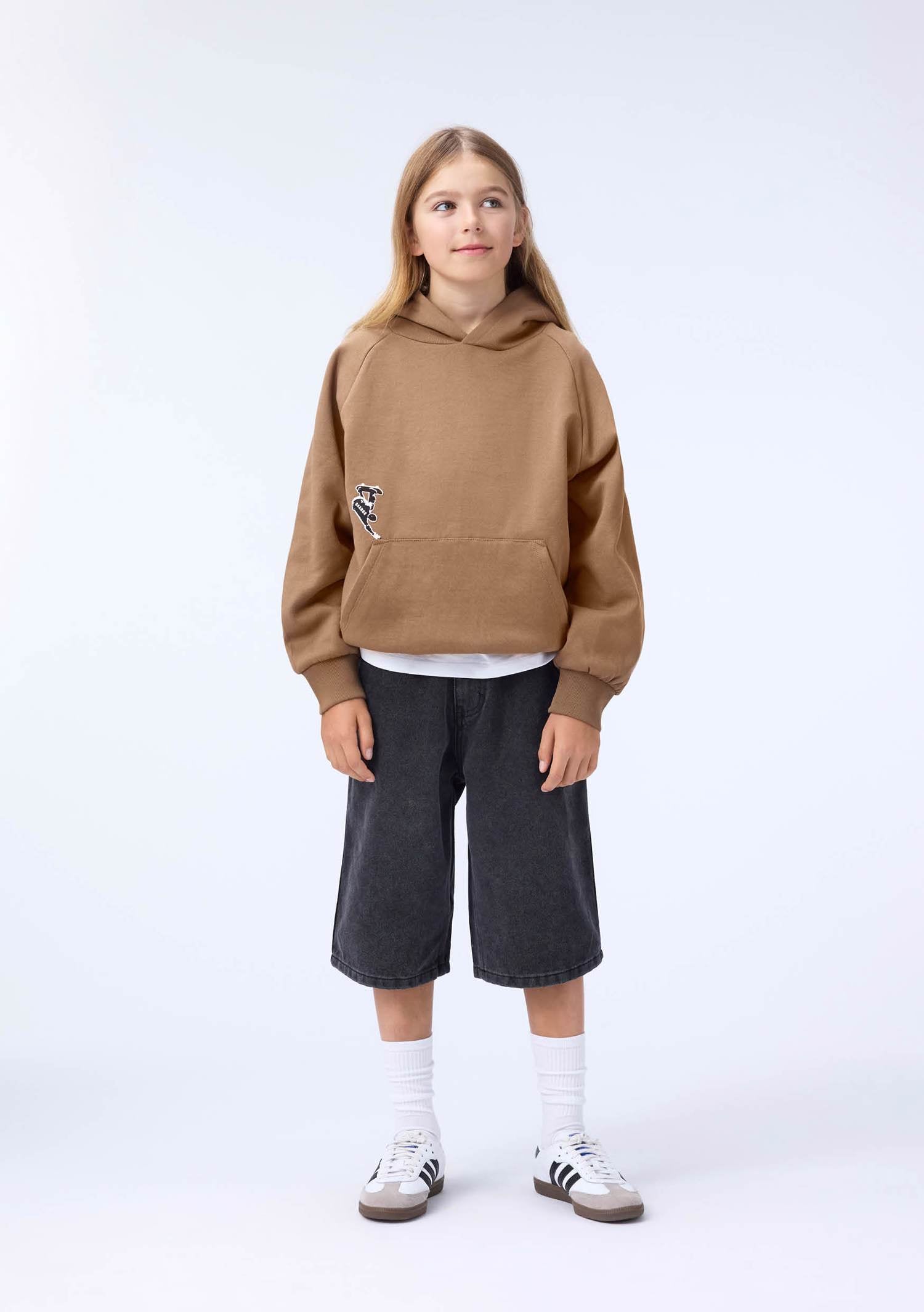 boy in brown sweatshirt with little skater on front