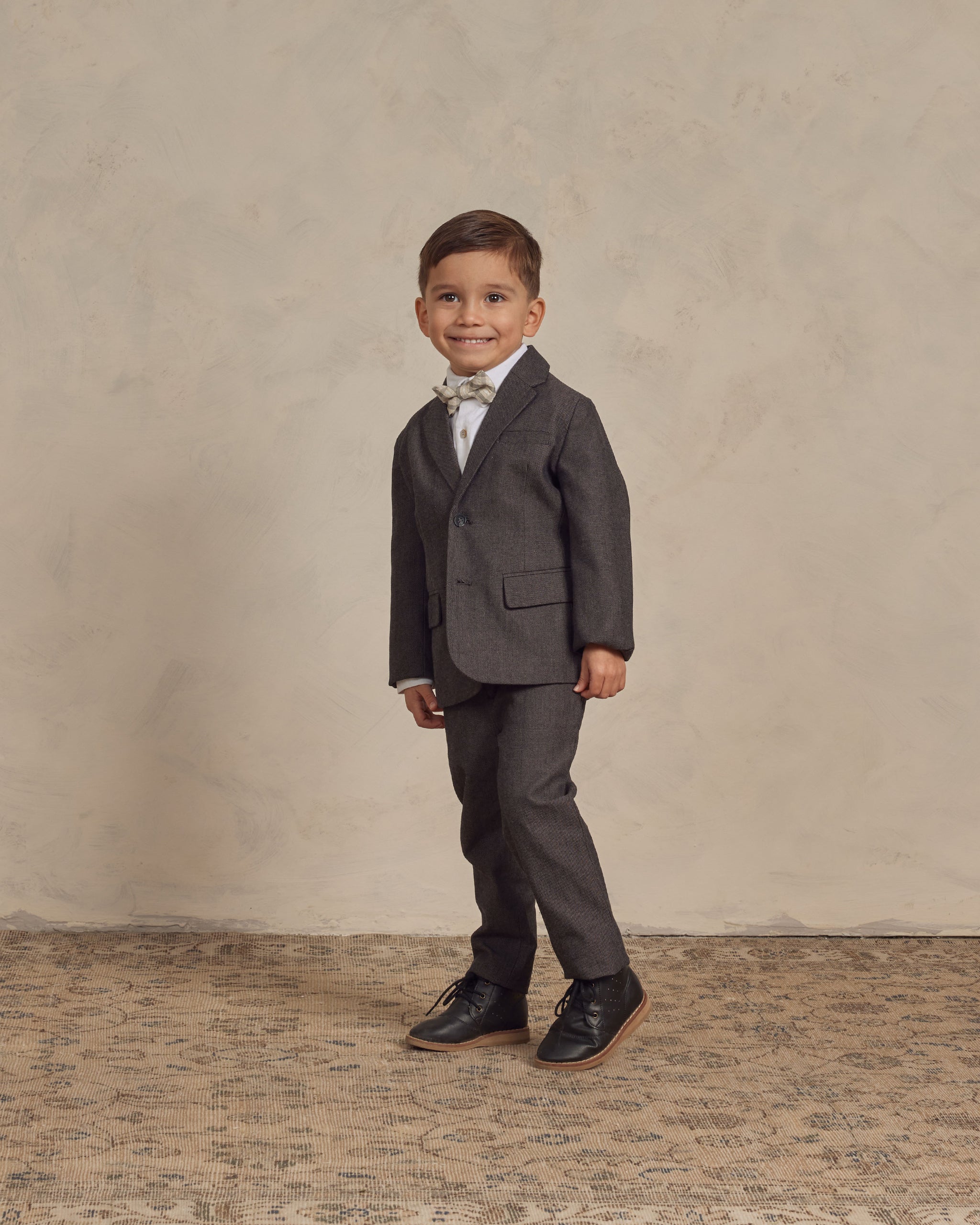 little boy in a dark grey dress suit