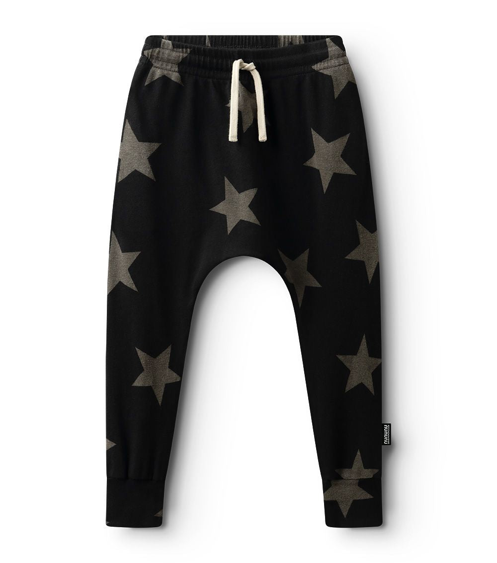This image features the "Star Baggy Pants" for children, presented in a striking black color adorned with a prominent grey star pattern. These pants are designed to be loose and comfortable, ideal for the active needs of both boys and girls.