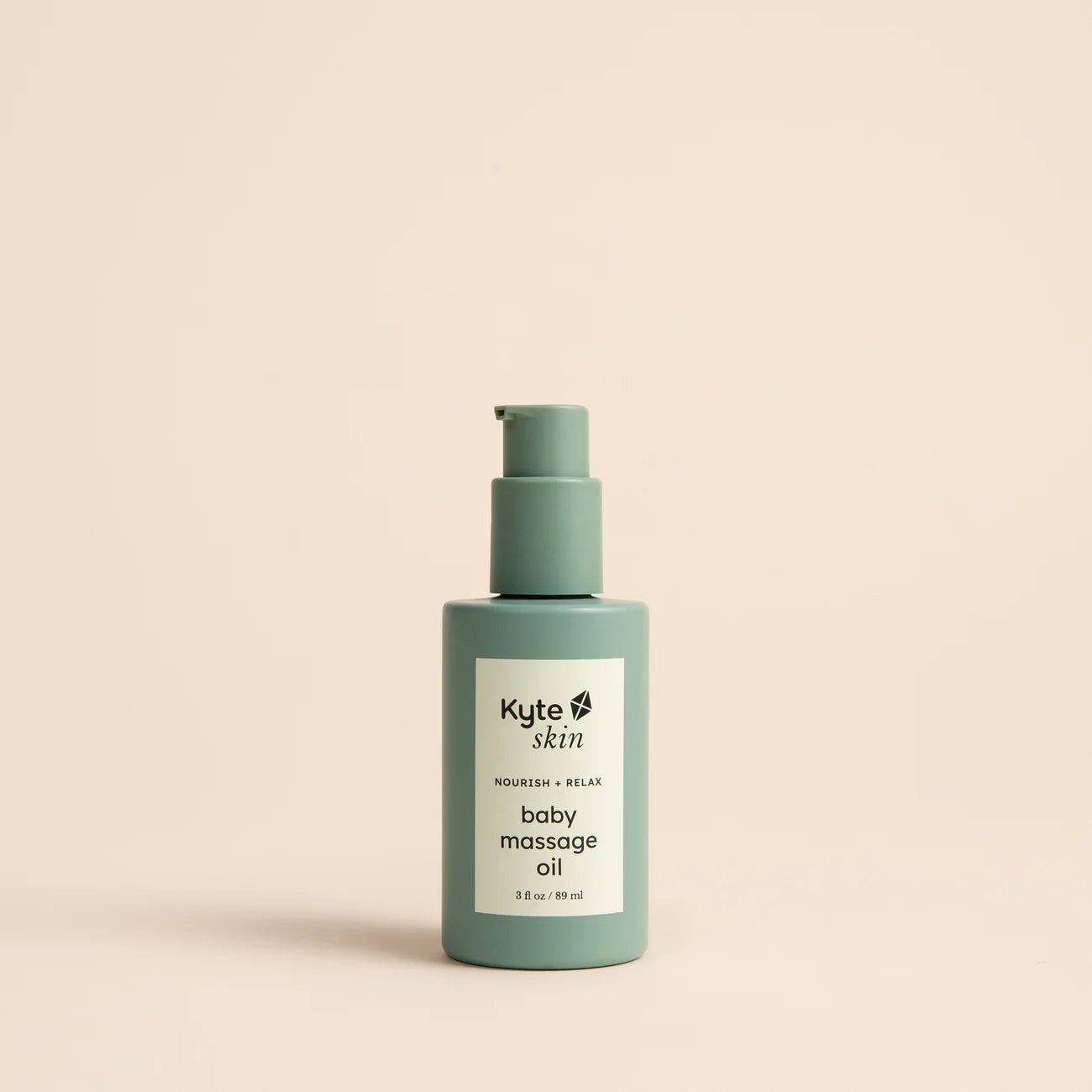 Kyte Skin baby massage oil bottle on a beige background