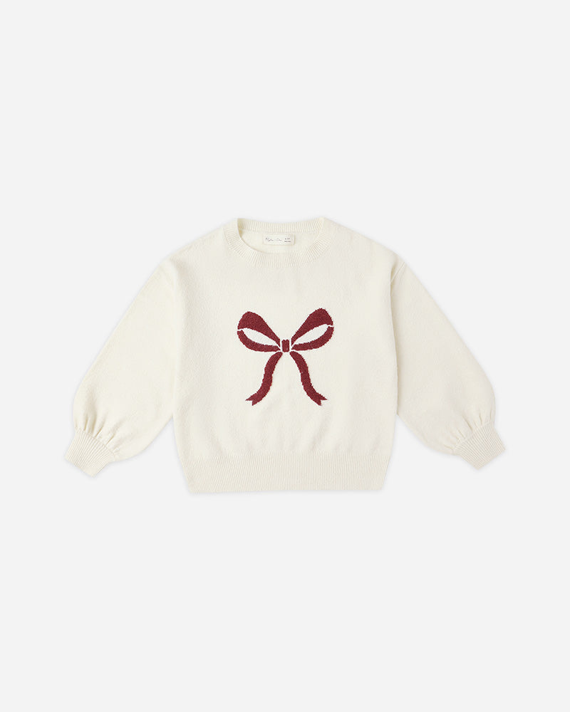 White sweater with a red bow design on a white background