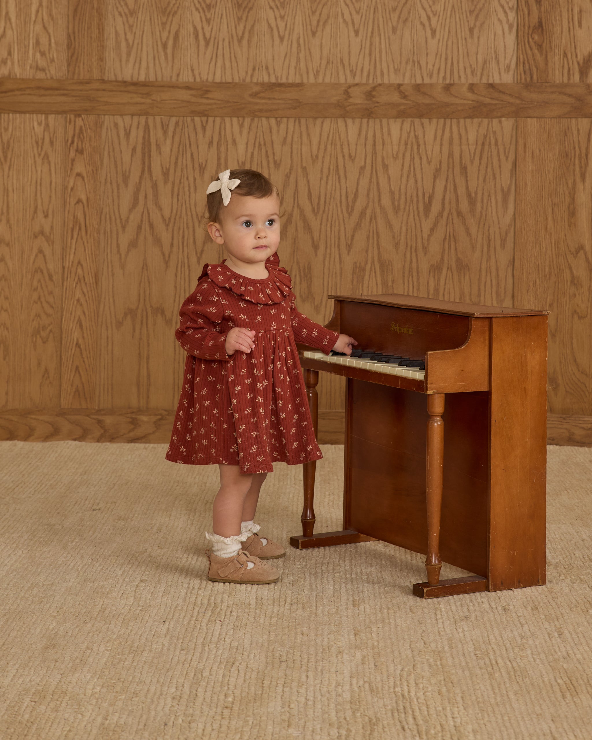 Young girl in a ruffle collar red dress with a floral print
