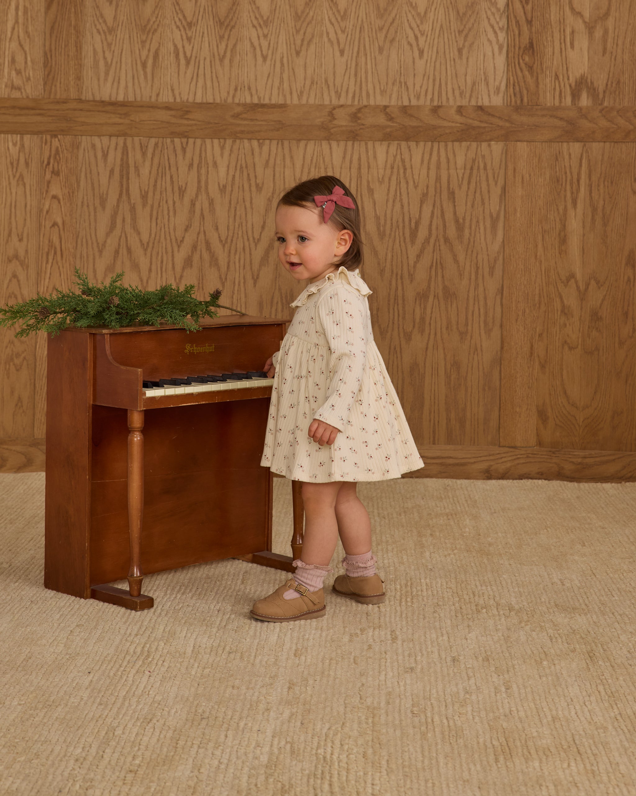 Young girl in a white ruffle collar dress with a floral pattern