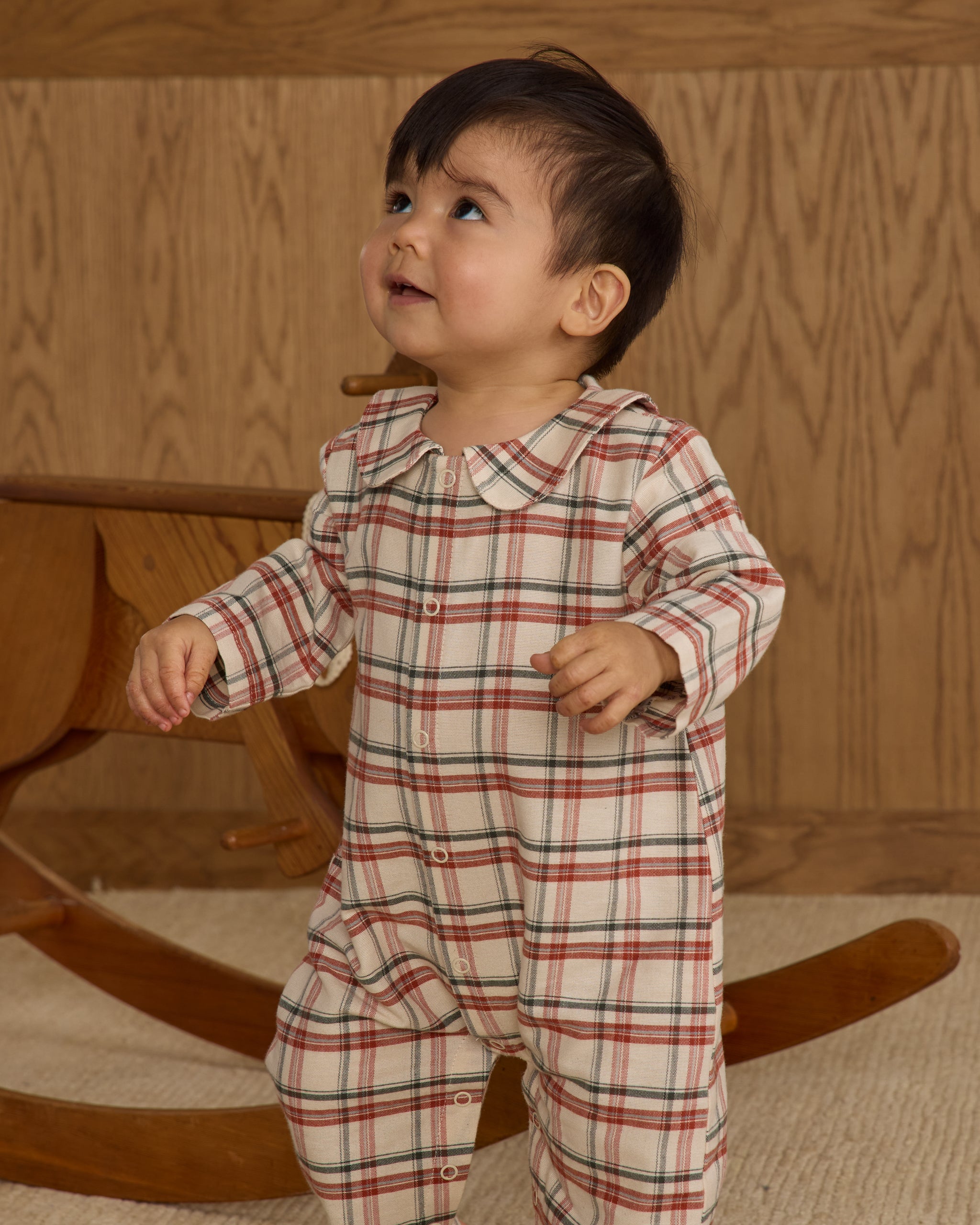 Baby in a plaid romper with snap buttons down the front