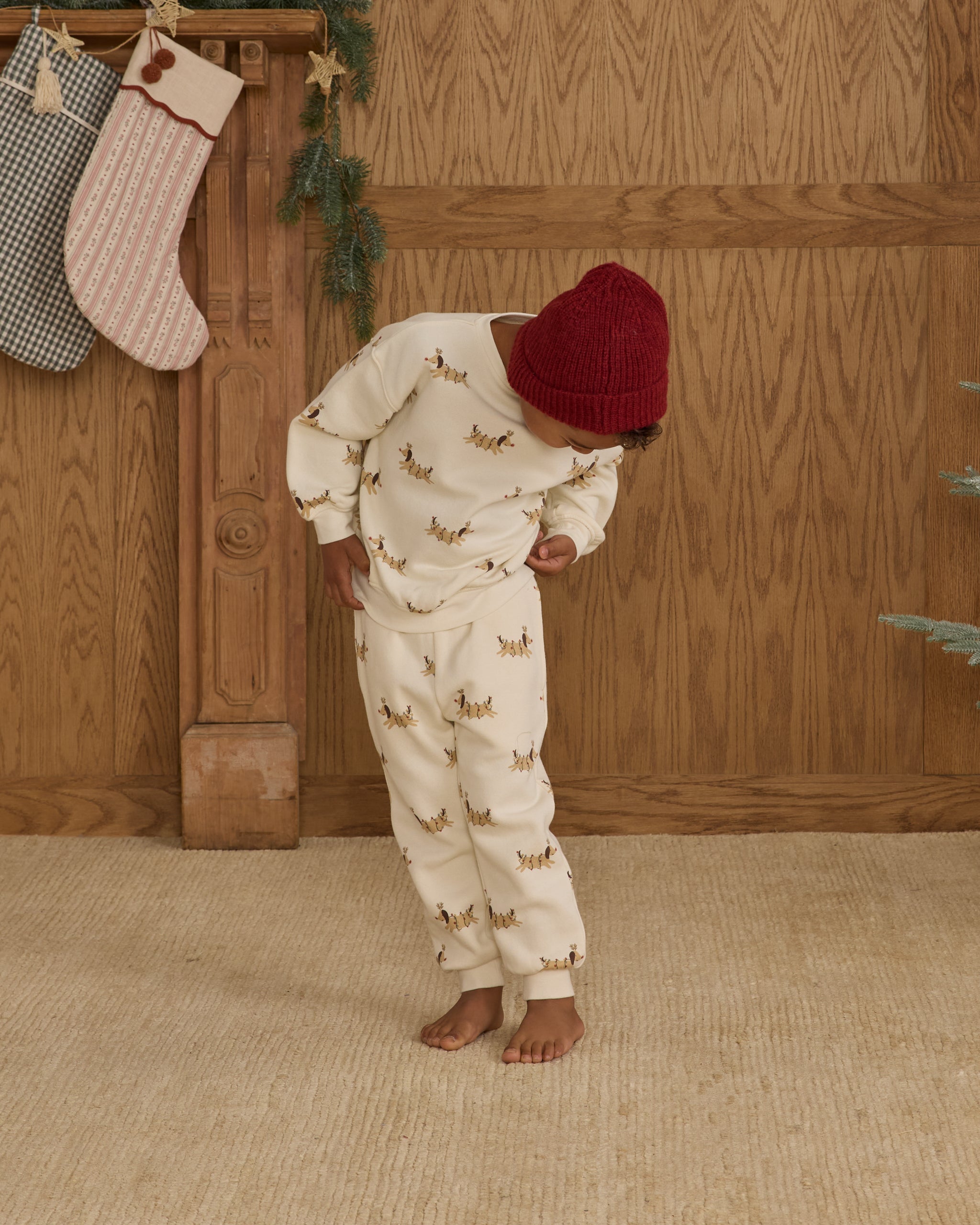 Child wearing white sweatpants with a Christmas dog pattern