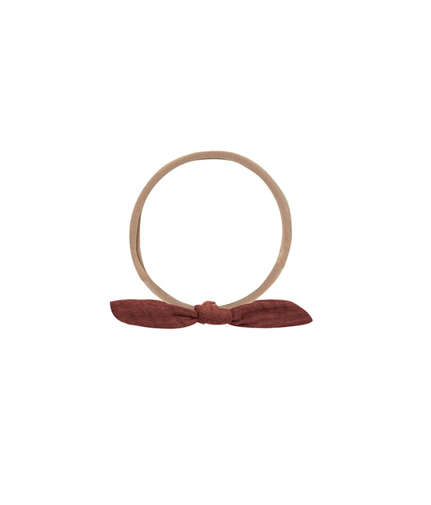 Beige hairband with a red bow on a white background