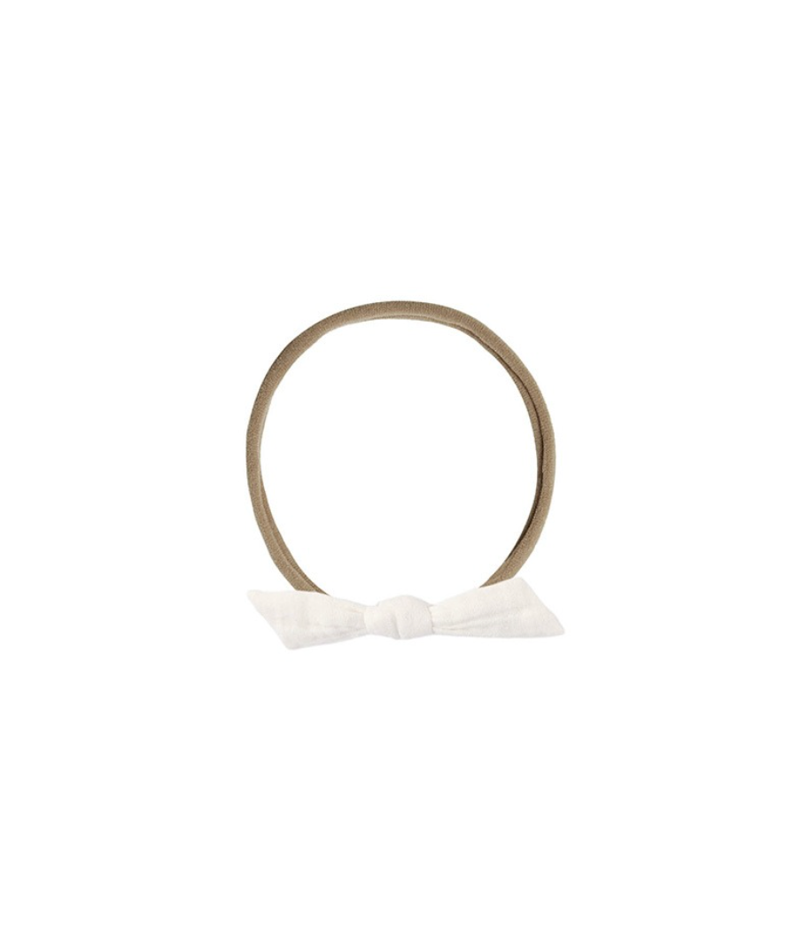 Beige elastic headband with a white bow on a white background