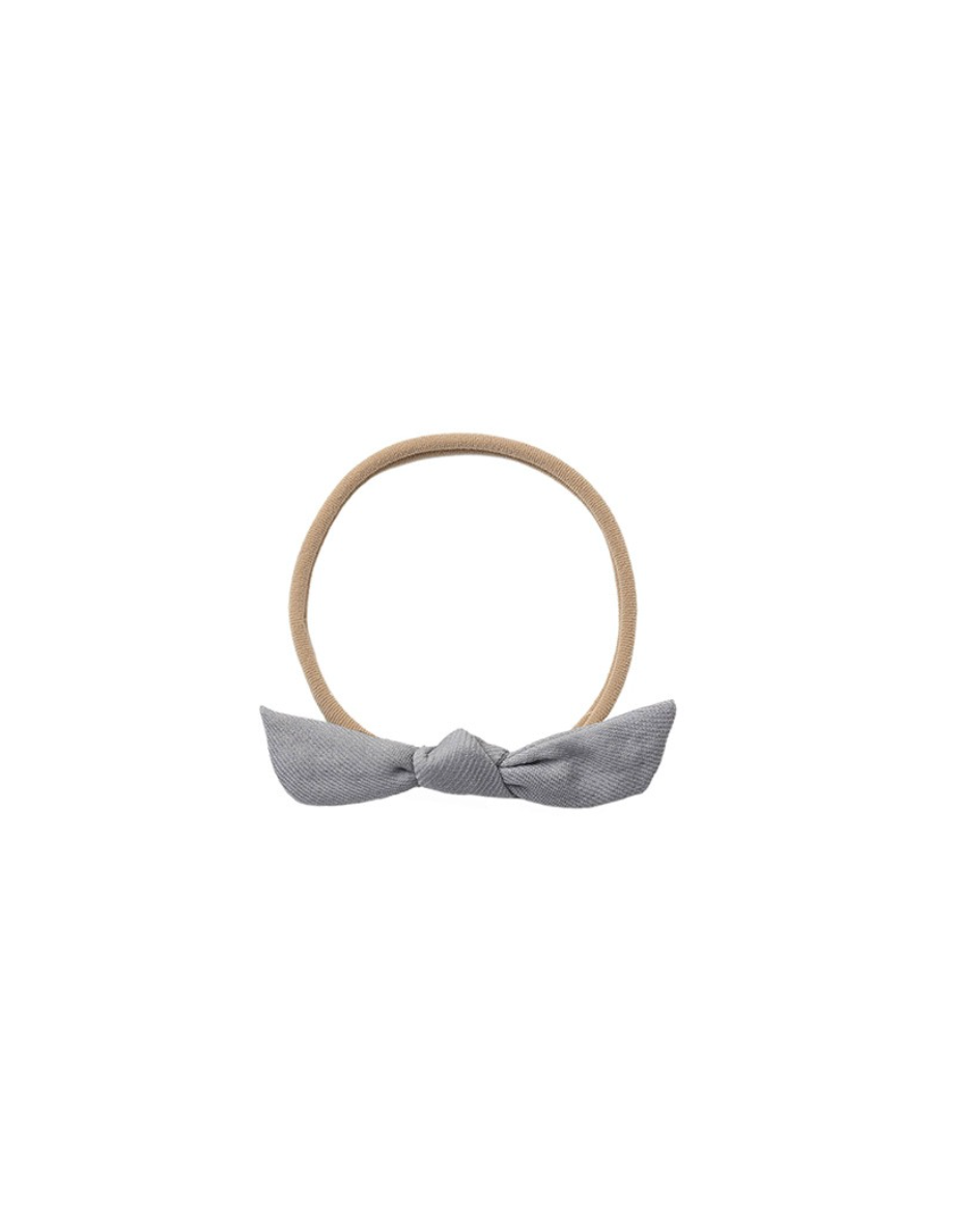 A light gray fabric bow headband with a tan elastic band, shown against a plain white background.