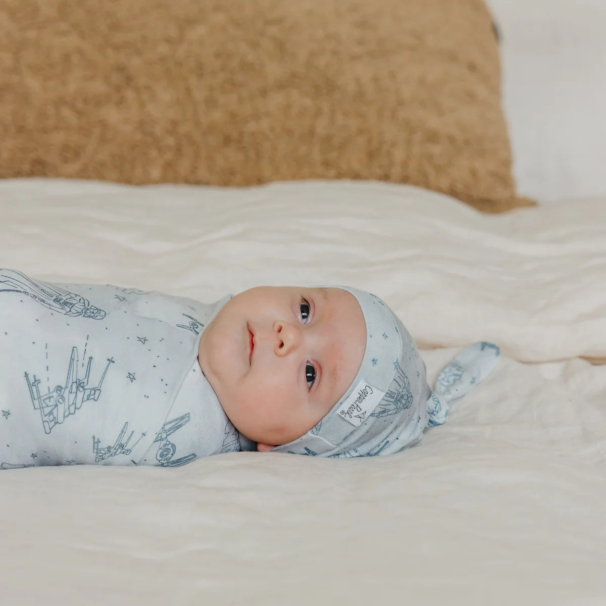 baby in matching hat and swaddle star wars themed
