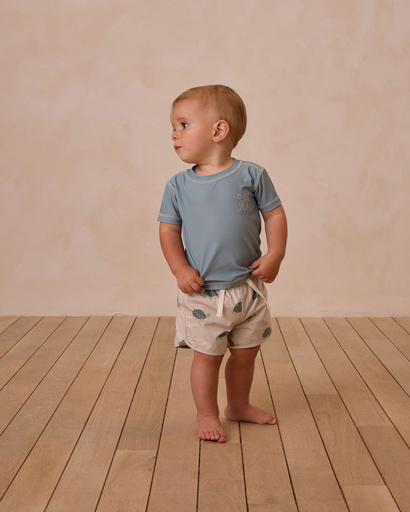 blue swim shirt and turtle swim trunks