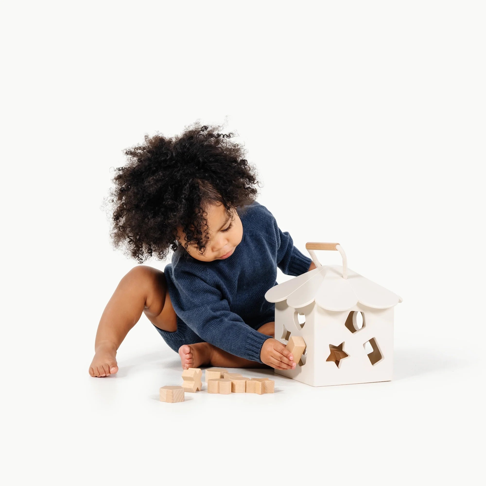 child playing with wooden shape sorter