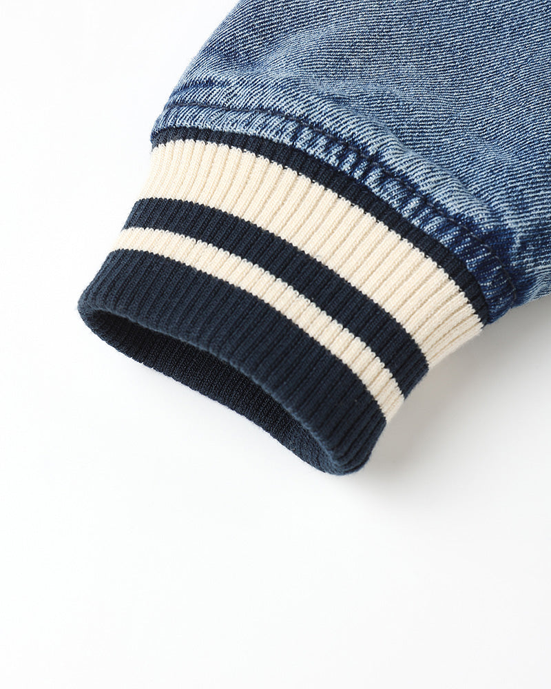 Close-up of a denim sleeve with striped cuffs on a white background