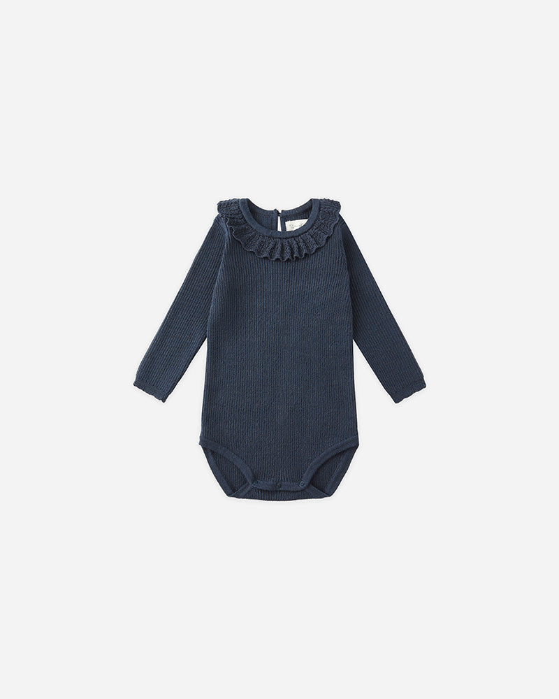 Navy blue baby bodysuit with ruffled neckline on a white background