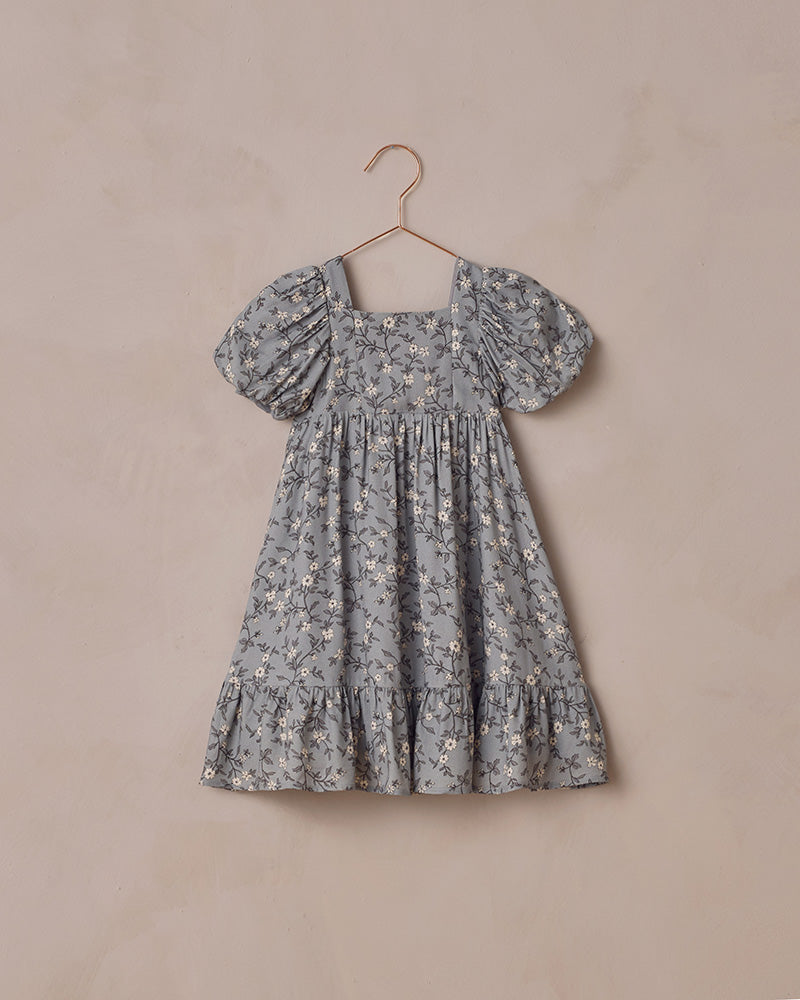 Floral dress on a hanger against a beige background