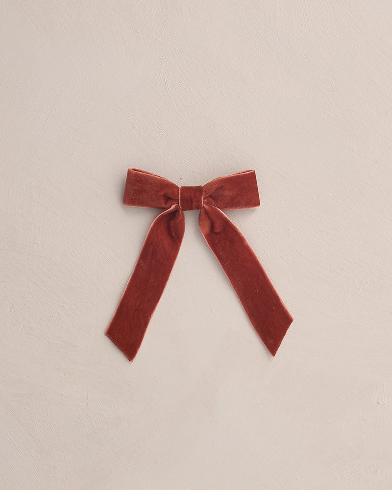 Red velvet bow on a beige background