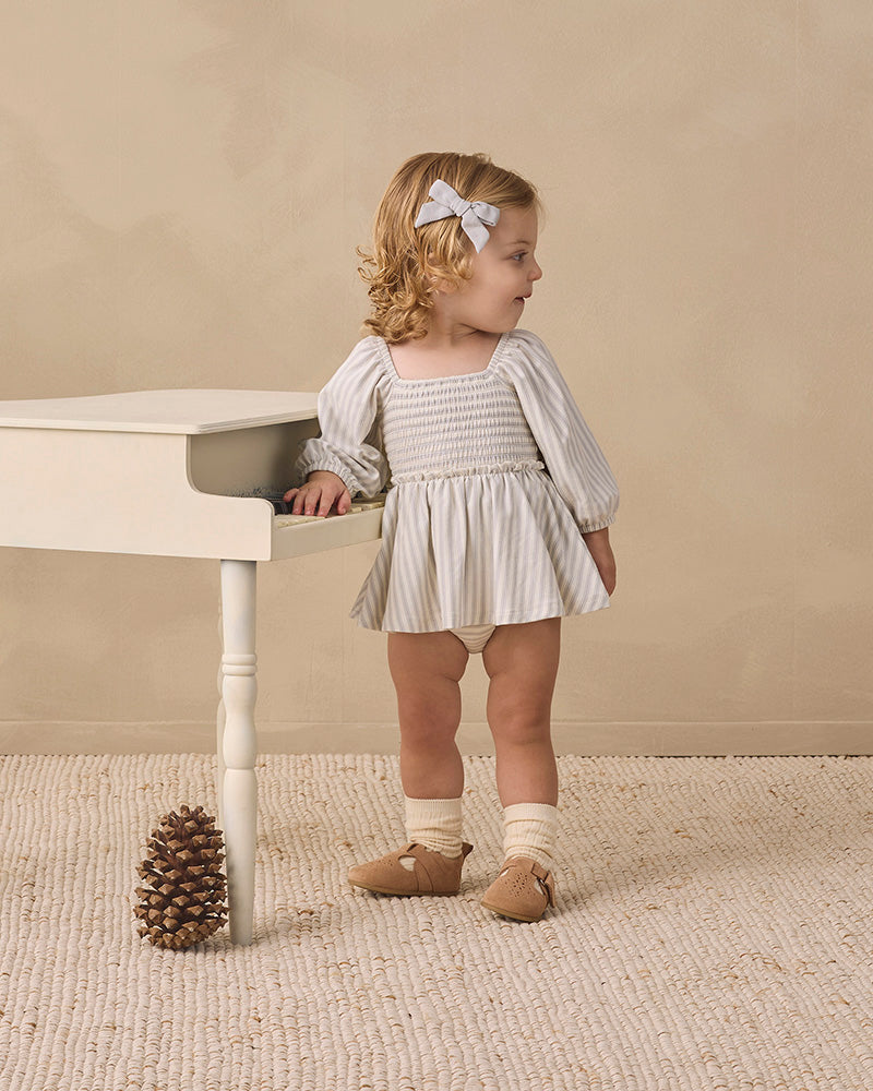 A baby romper with a smocked bodice, square neckline, and puffed sleeves, featuring a white and gray striped pattern, shown on a plain white background.