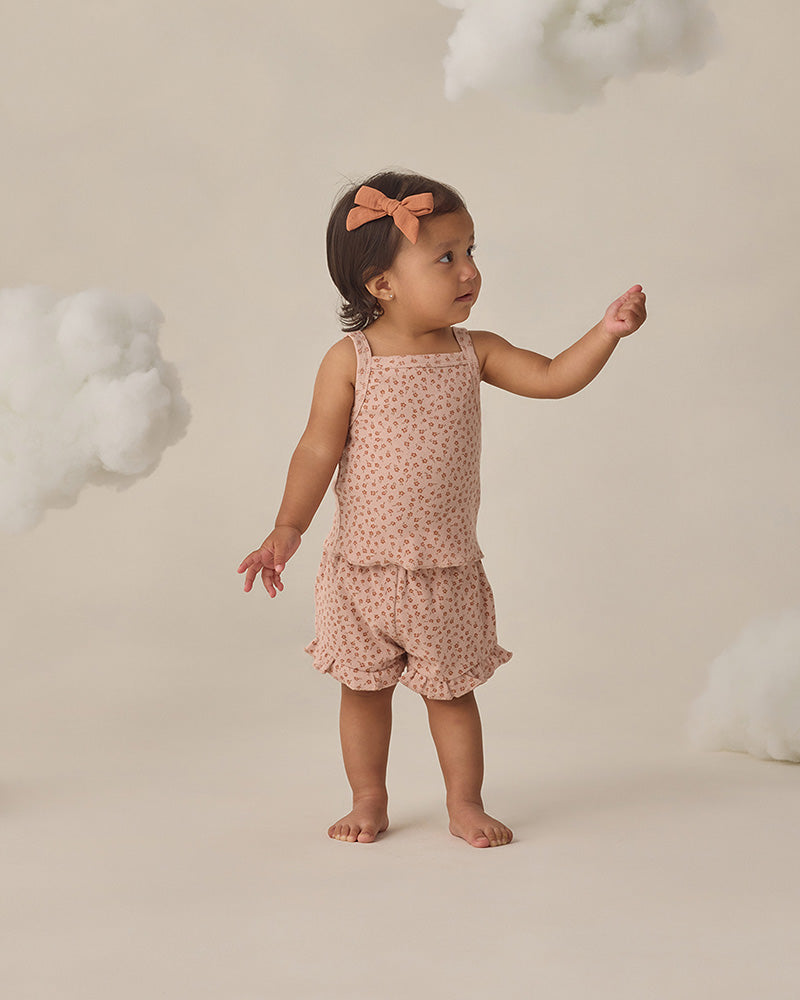 Little girl in a two piece light pink floral set with ruffle detailing