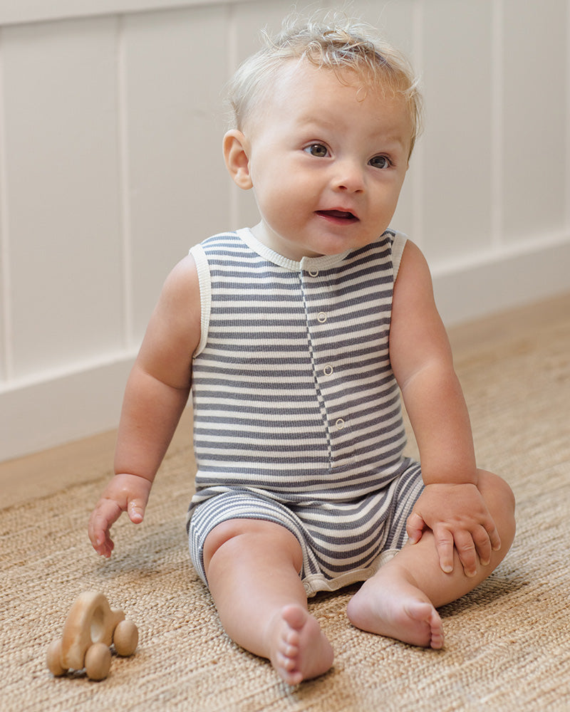 Baby wearing a blue and white striped button up romper