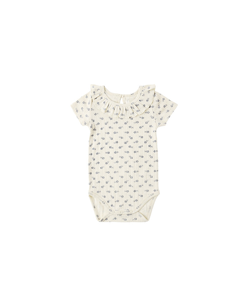 Baby romper with a subtle floral pattern on a white background