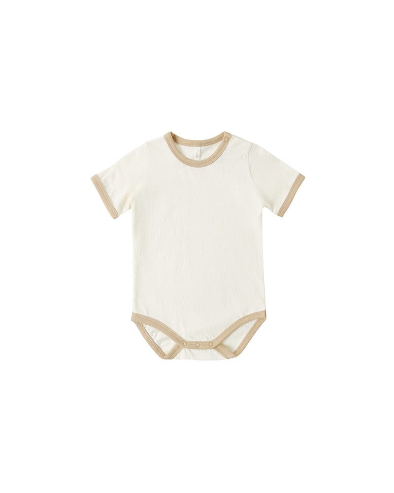 White baby bodysuit with beige trim on a white background