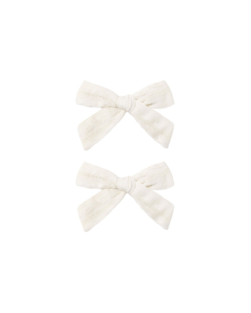 Two white bow clips on a white background