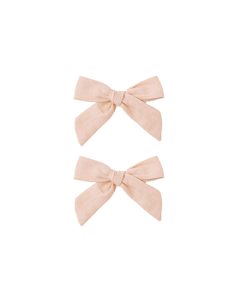 Two blush pink hair bows on a white background
