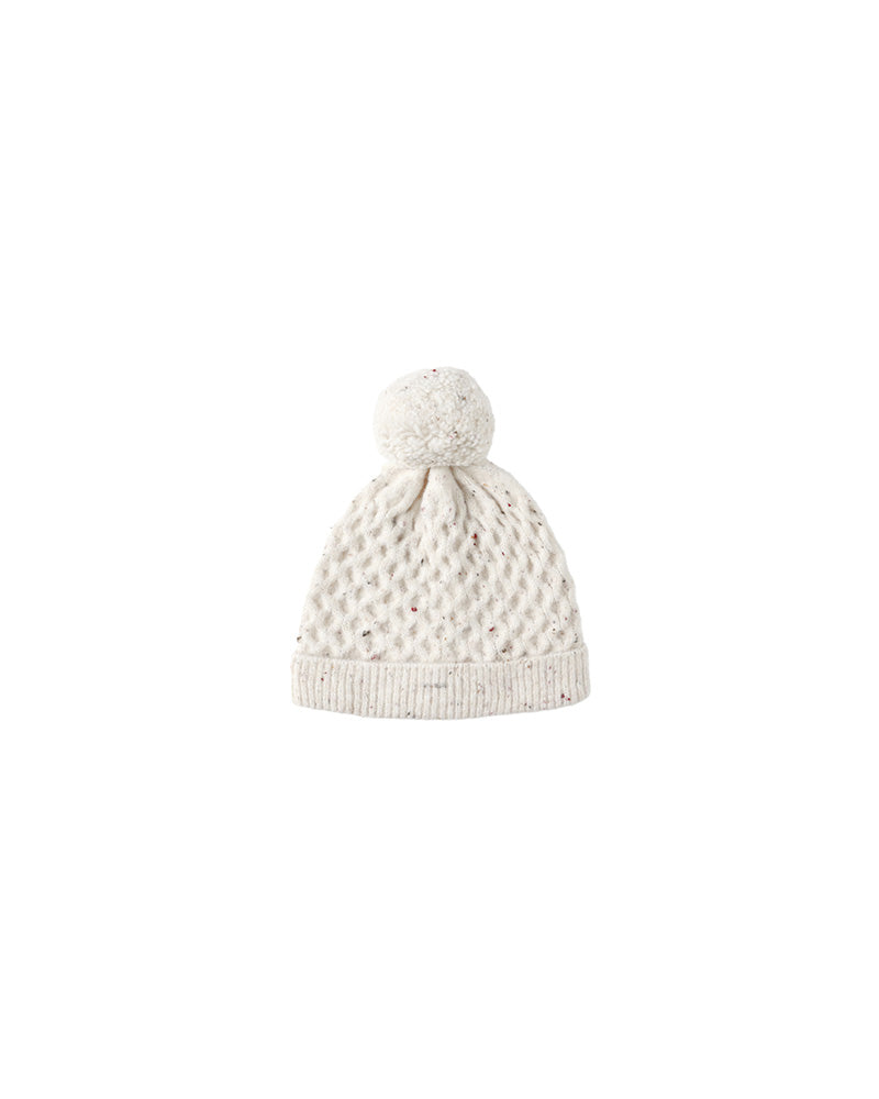 White speckled knit beanie with a pom-pom on a white background