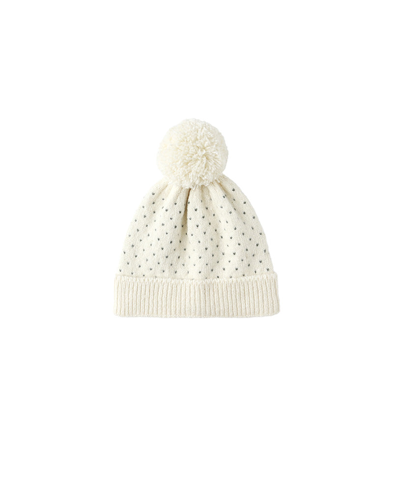 White speckled knit beanie with pom-pom on a white background