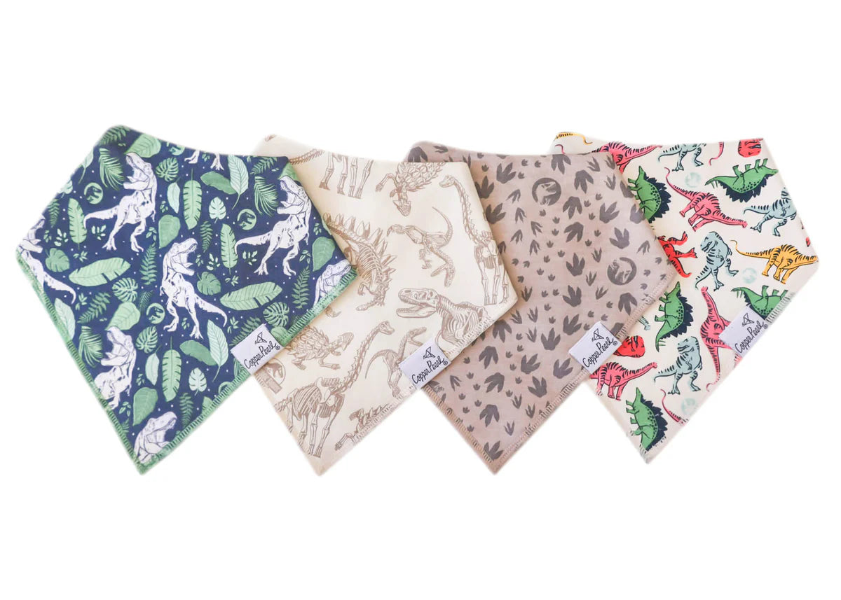 A set of four bandana bibs with various patterns including a dinosaur print and dinosaur paw prints, displayed on a white background.