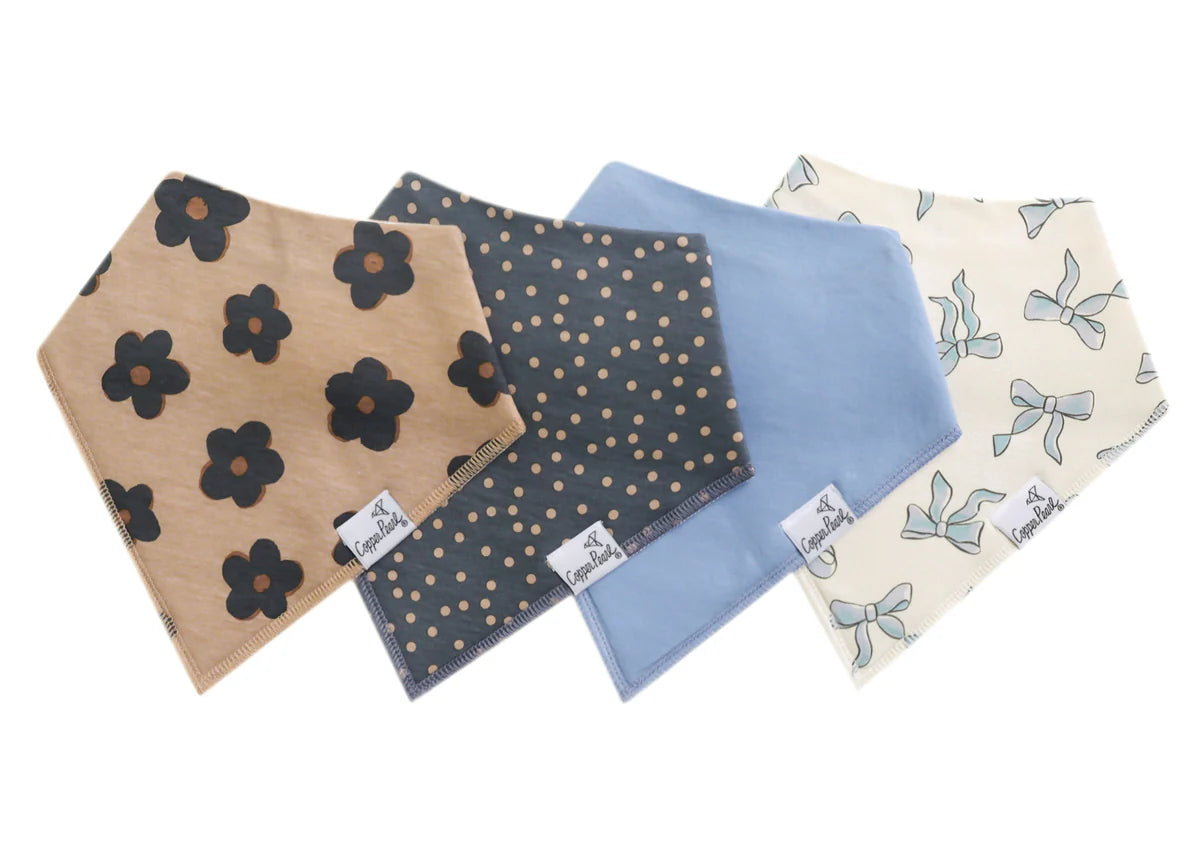 A set of four folded bandana bibs for babies, laid out on a white background. They are adorned with different patterns including a floral design and dots, in various colors such as blue and beige.