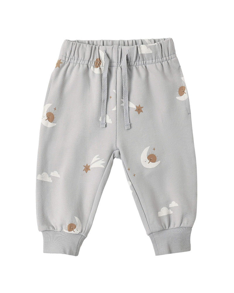 Light gray baby jogger pants with a celestial print of crescent moons, stars, and clouds, featuring an elastic waistband with drawstrings and ribbed ankle cuffs.