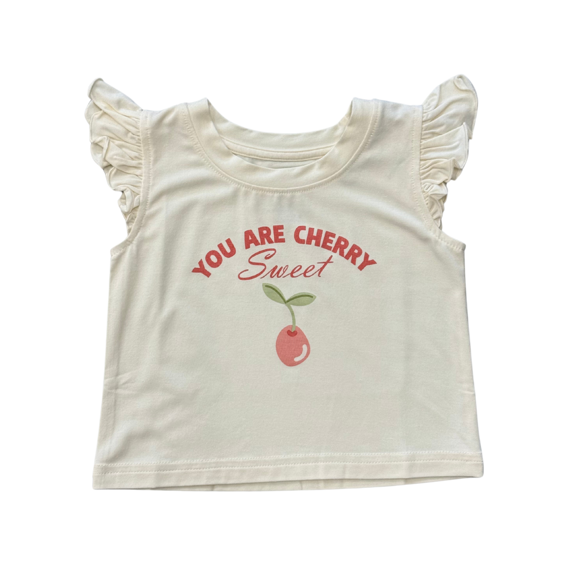 White crop top with red cherry graphic and ruffled sleeves on a white background