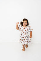 Child wearing a western patterned dress with ruffle sleeves 