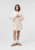 Person wearing a white pleated skirt