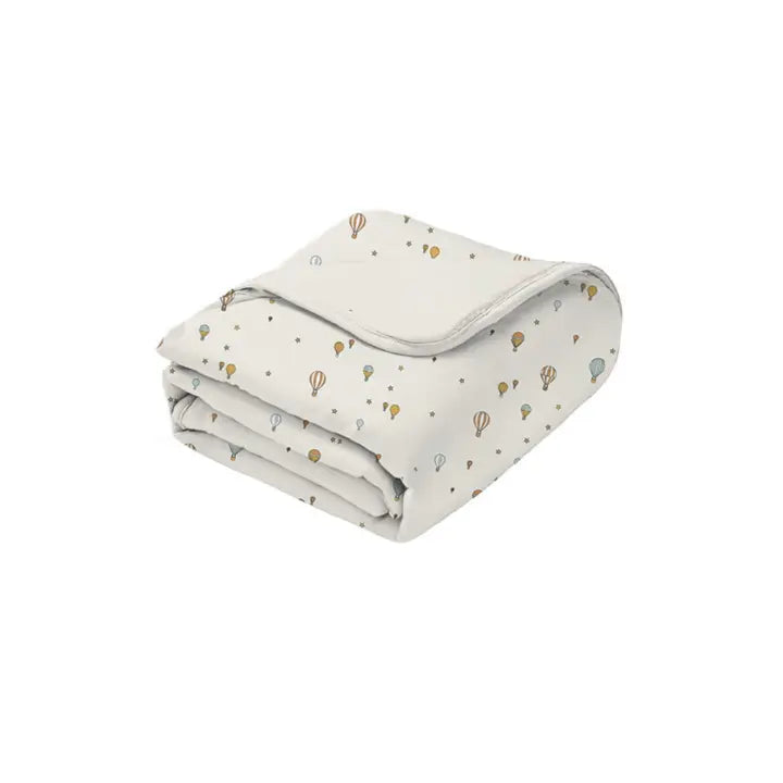 Folded blanket with hot air balloon pattern on a white background