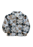 A baby quilted jacket with a patchwork design in beige, brown, dark blue, and white, featuring a Peter Pan collar and front buttons.