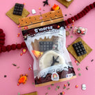 S'mores-themed play dough set with food accessories on a pink background. 