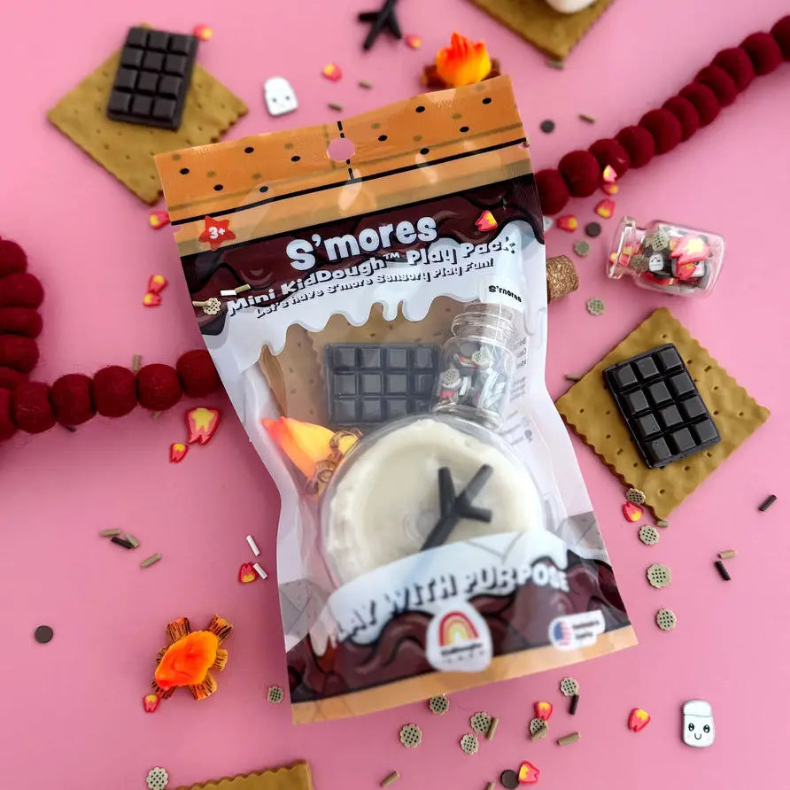S'mores-themed play dough set with food accessories on a pink background. 