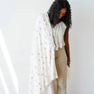 Woman holding a white floral stretch swaddle blanket