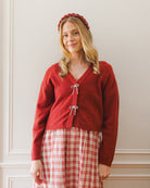 Red cardigan with bow details on the front. 