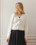 Ivory cardigan with bow details on the front.