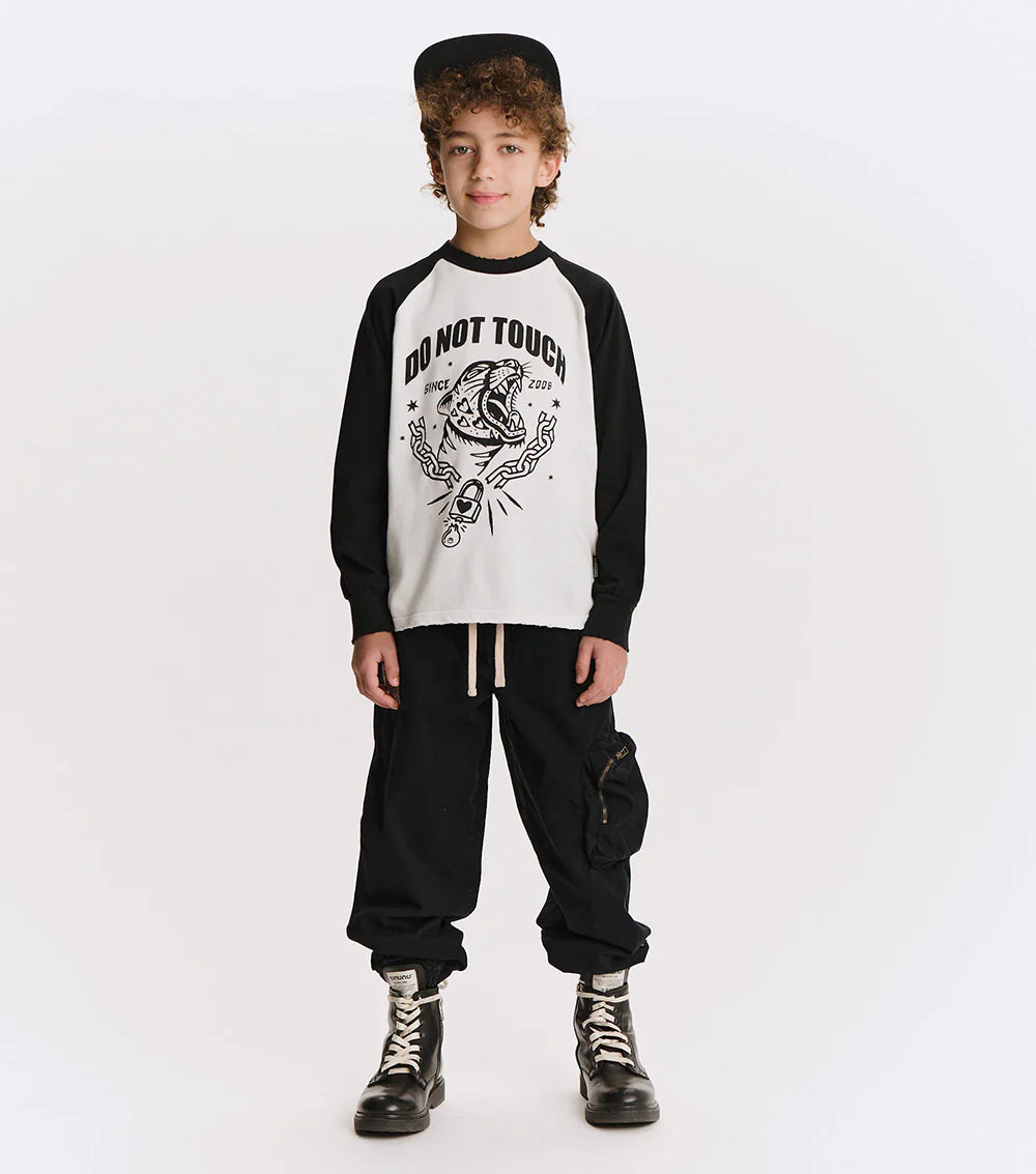 Child wearing a black and white 'Do Not Touch' shirt with graphic design on a white background