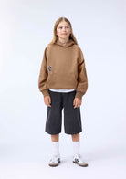 boy in brown sweatshirt with little skater on front 