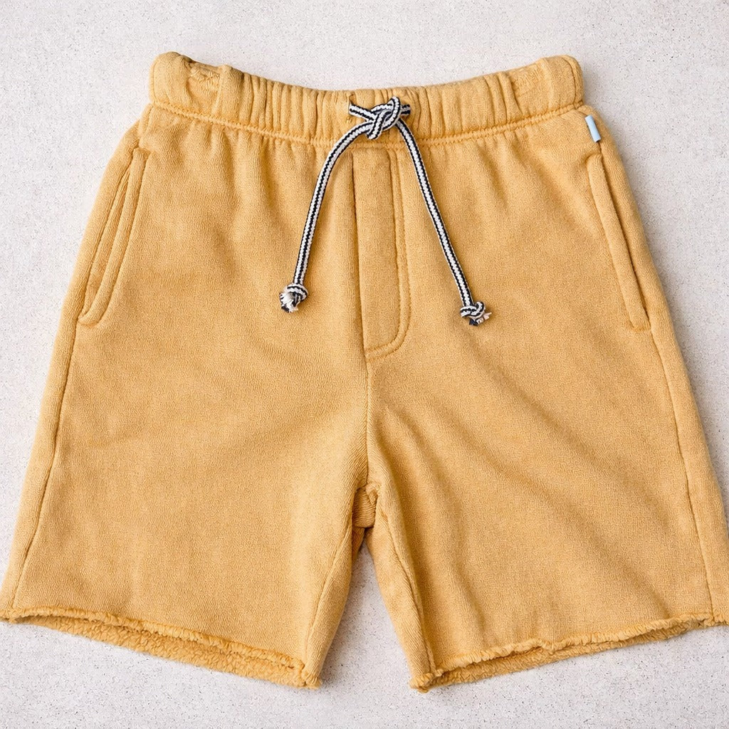 Yellow shorts with a drawstring on a light gray background