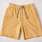 Yellow shorts with a drawstring on a light gray background