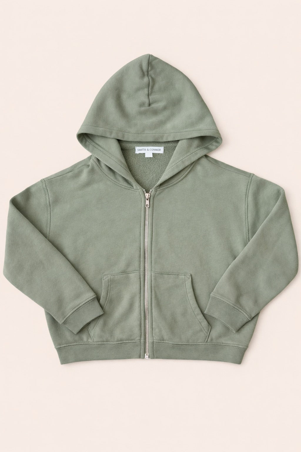 Green hoodie with a zipper on a beige background