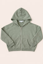 Green hoodie with a zipper on a beige background