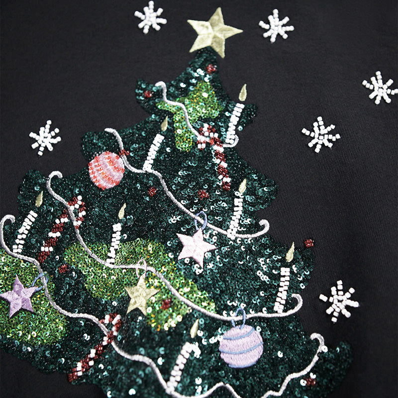 Decorative Christmas tree design with lights, ornaments, and snowflakes on a black sweatshirt