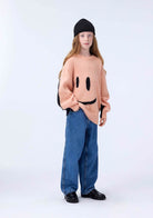 Girl in Pink and Black Smiley Sweater 